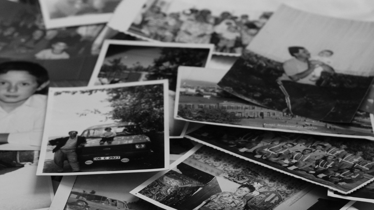 A scattered pile of old black-and-white family photographs